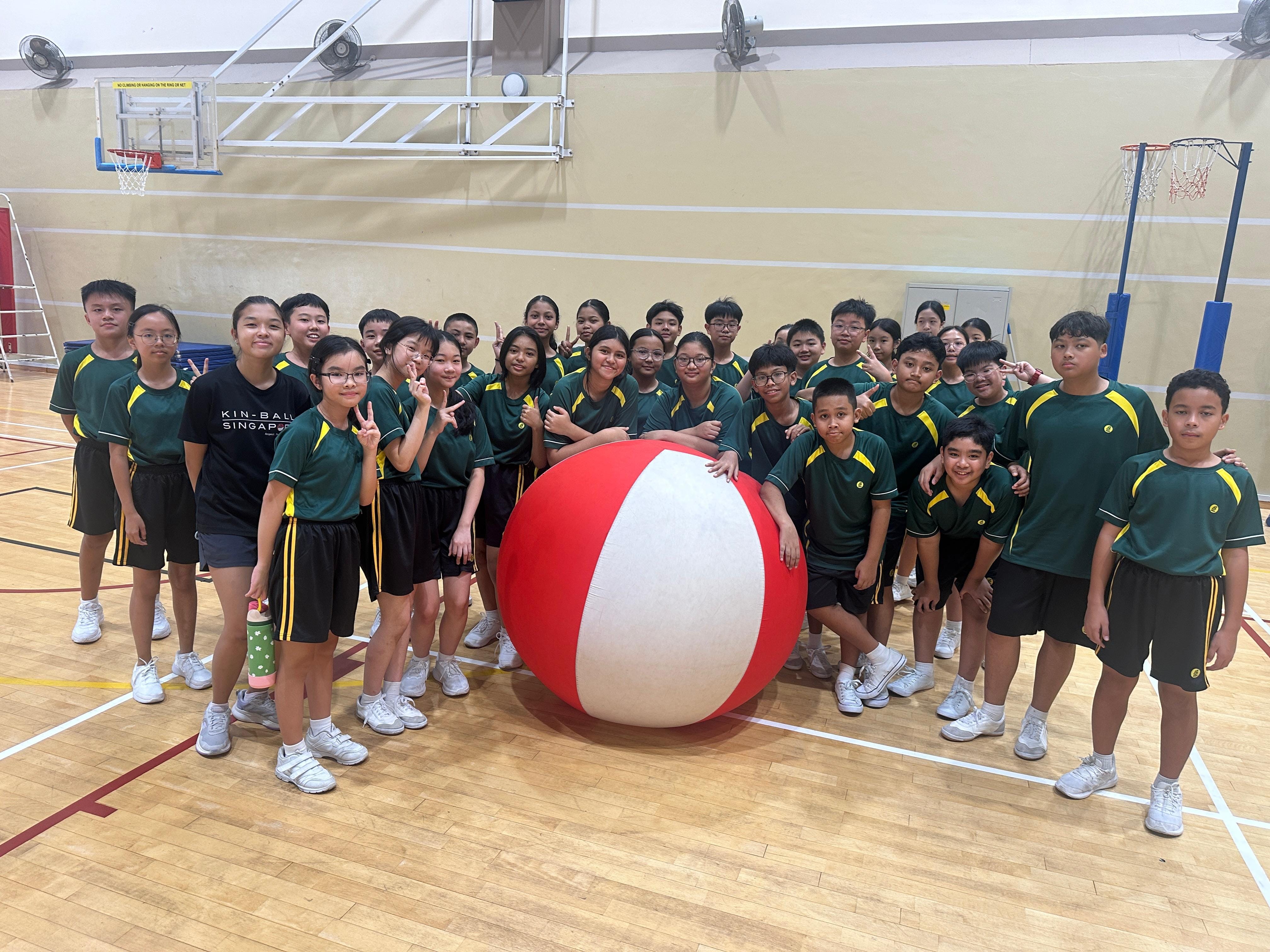 A class of students standing with their Kinball